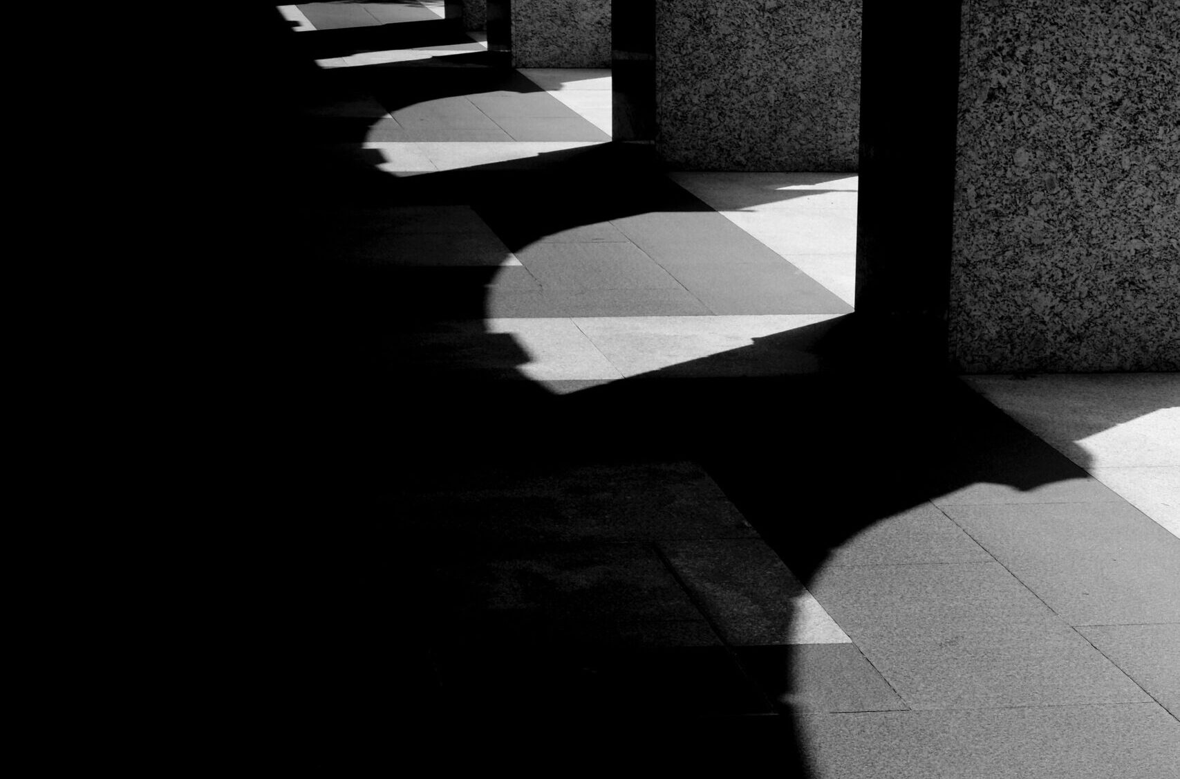 Säulen werfen Schatten auf einen Gang.